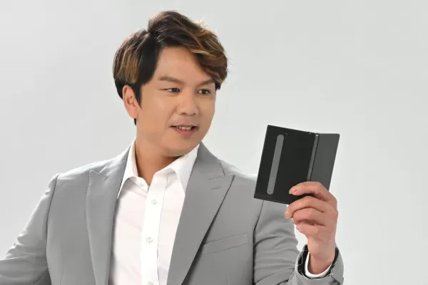 A person in a suit holding a half folded Readmoo mooInk V in their hand.